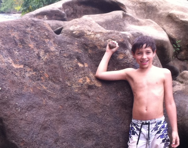 boy proud of himself holding rock removing graffiti